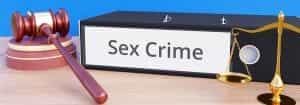 A folder that states "Sex Crime" next to a gavel and libra scale.