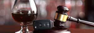 Photo of a gavel, alcohol, and car keys.